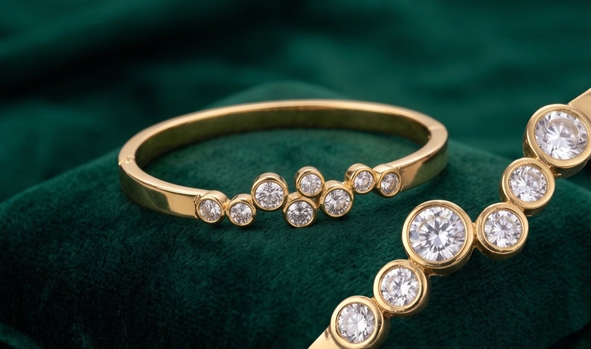 Gold-tone bangle with bezel-set stones on green velvet